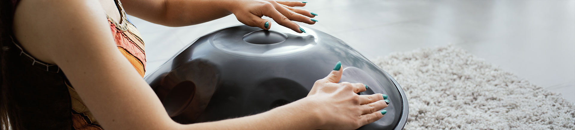 Dettaglio della mani di una ragazza che suona l'handpan